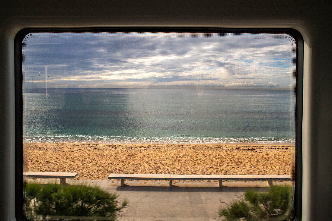 Küste von Maresme. Fensterlandschaft im Modernisme-Zug, der an der katalanischen Küste entlangfährt und an Gaudí-Gebäuden und historischen gastronomischen Stätten Halt macht: Barcelona, Martaro und Canet de Mar