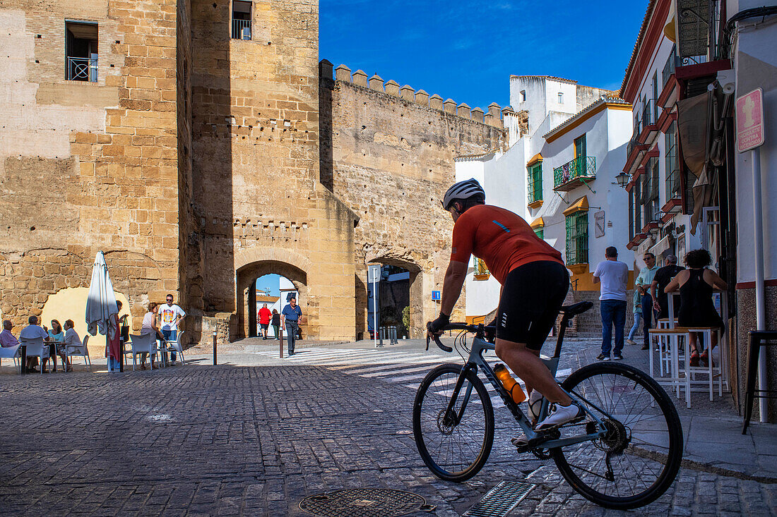Cyclist in Alcazar de la Puerta de Sevilla. The Seville Gate Citadel. Old town Carmona Seville Andalusia South of Spain.