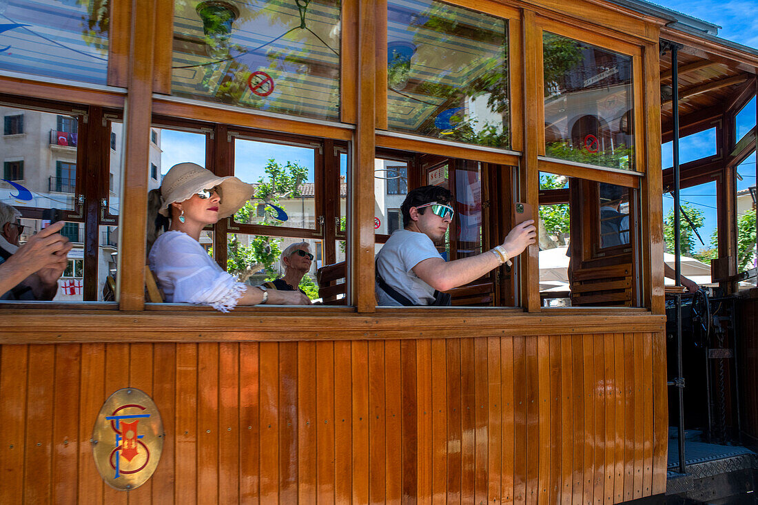 Tourists inside the vintage tram at the Soller village center. The tram operates a 5kms service from the railway station in the Soller village to the Puerto de Soller, Soller Majorca, Balearic Islands, Spain, Mediterranean, Europe.