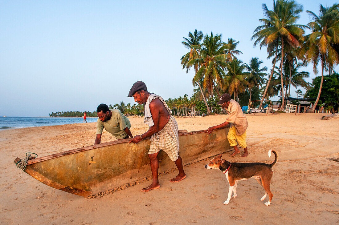 Einheimische Fischer am Strand von Las Terrenas, Samana, Dominikanische Republik, Karibik, Amerika. Tropischer Karibikstrand mit Kokosnusspalmen