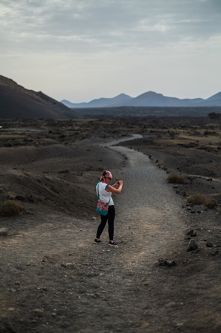 Volcan del Cuervo (Krähenvulkan) ein Krater, der auf einem Rundweg in einer kargen, felsigen Landschaft erkundet wird