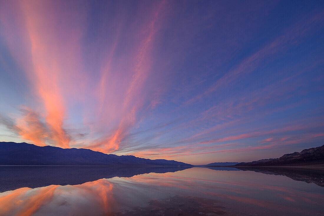 Sonnenuntergang über den Panamint Mountains mit dem überfluteten Badwater Basin, das den Lake Manly nachbildet; Death Valley National Park, Kalifornien