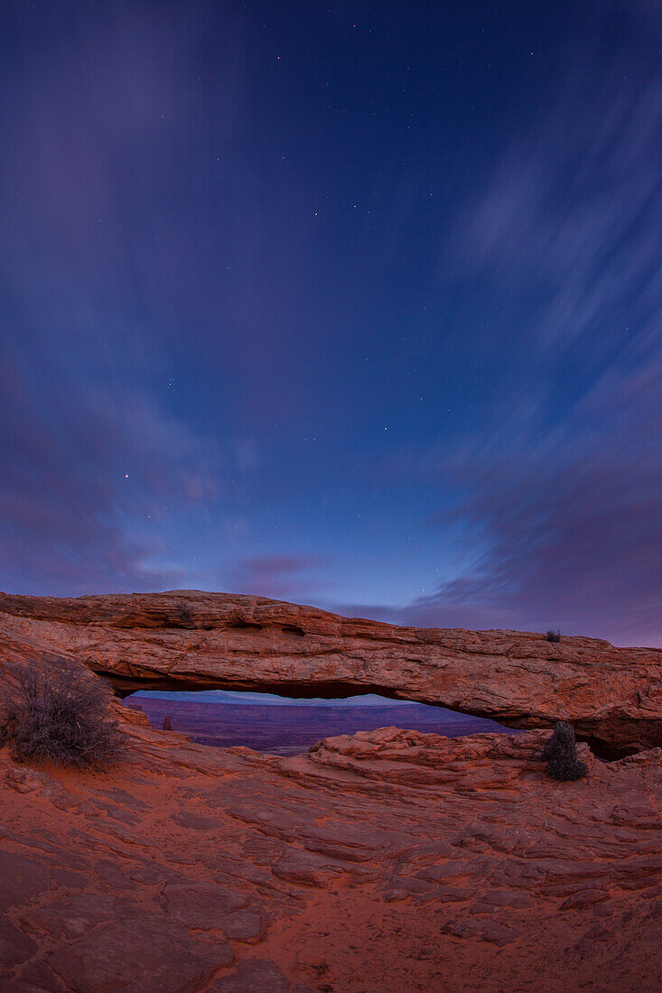 Stars and clouds over Mesa Arch in the Island in the Sky District of Canyonlands National Park in Utah.