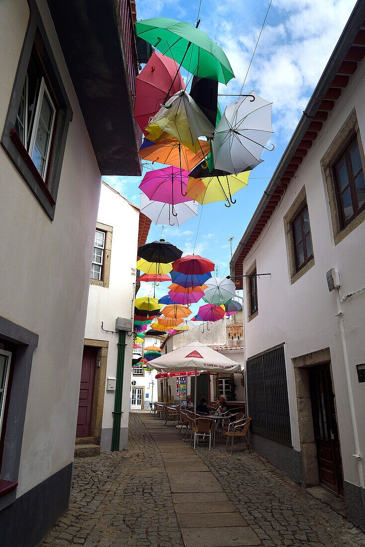 Von Regenschirmen bedeckte Straße Afonso de Albuquerque. Almeida, Portugal