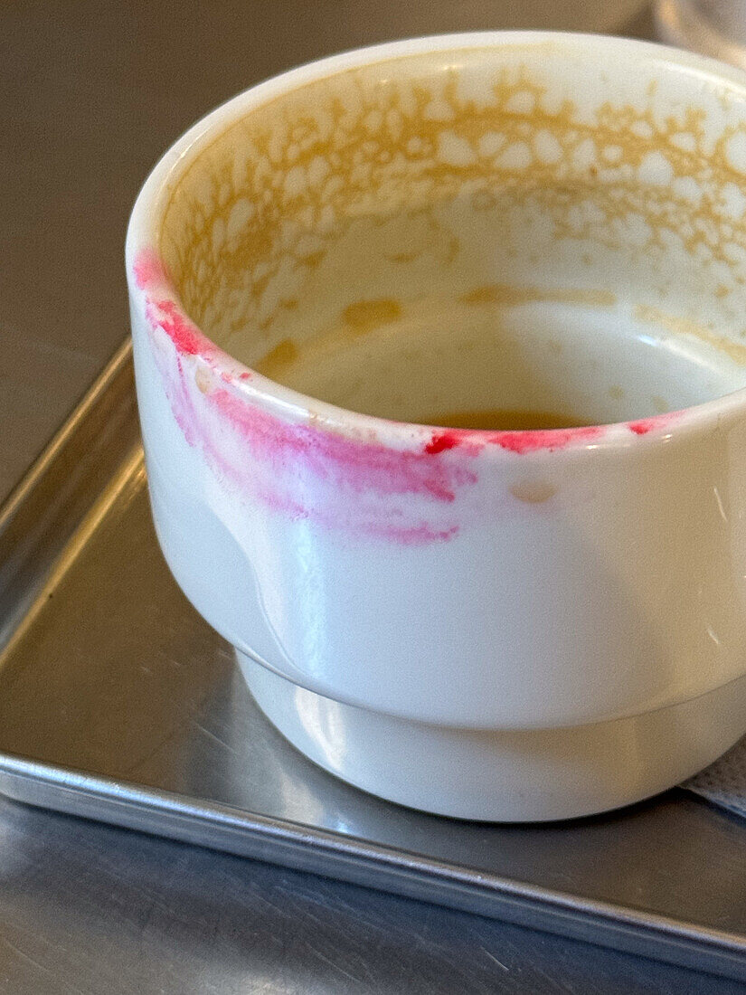 Female lipstick mark left on cup of coffee
