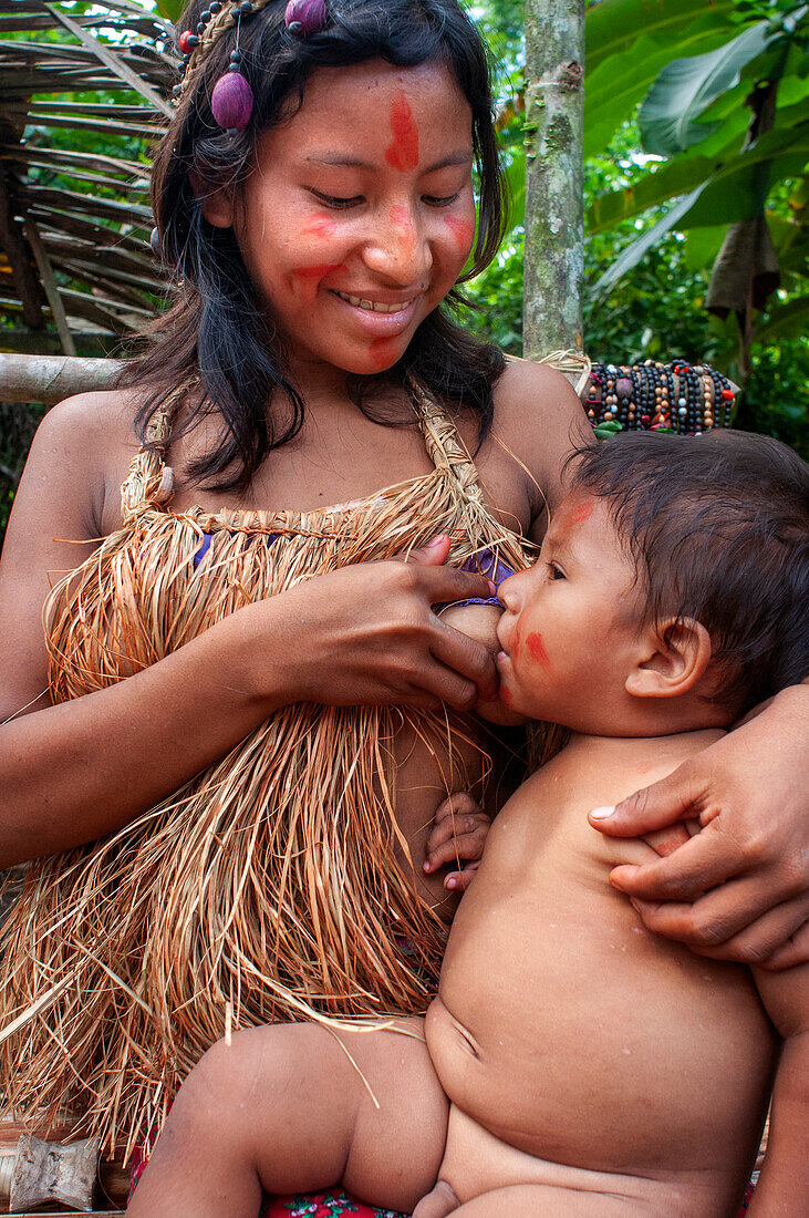 Frauen stillen ihr Baby Yagua-Indianerinnen leben ein traditionelles Leben in der Nähe der amazonischen Stadt Iquitos, Peru