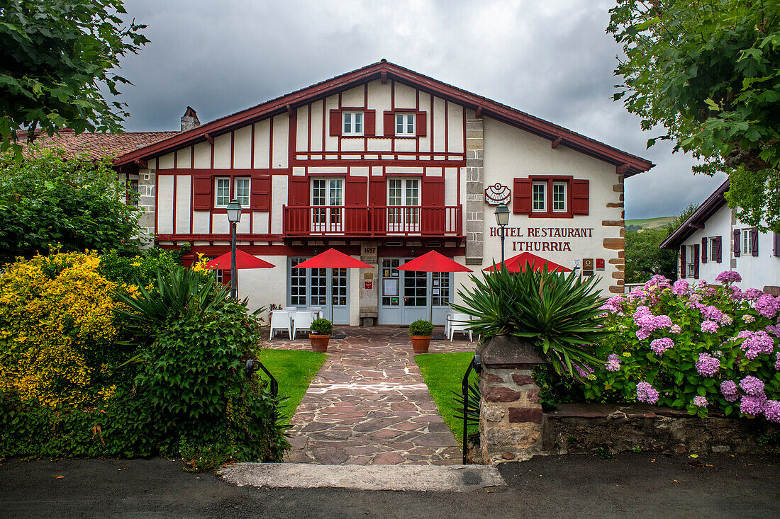 Baskenland. Das Dorf Ainhoa hat seine traditionellen Häuser aus dem 16. Jahrhundert in Rot- und Grüntönen gehalten. Hier das Hotel und Restaurant Ithurria. Traditionelle baskische Gebäude im Dorf Ainhoa, Frankreich