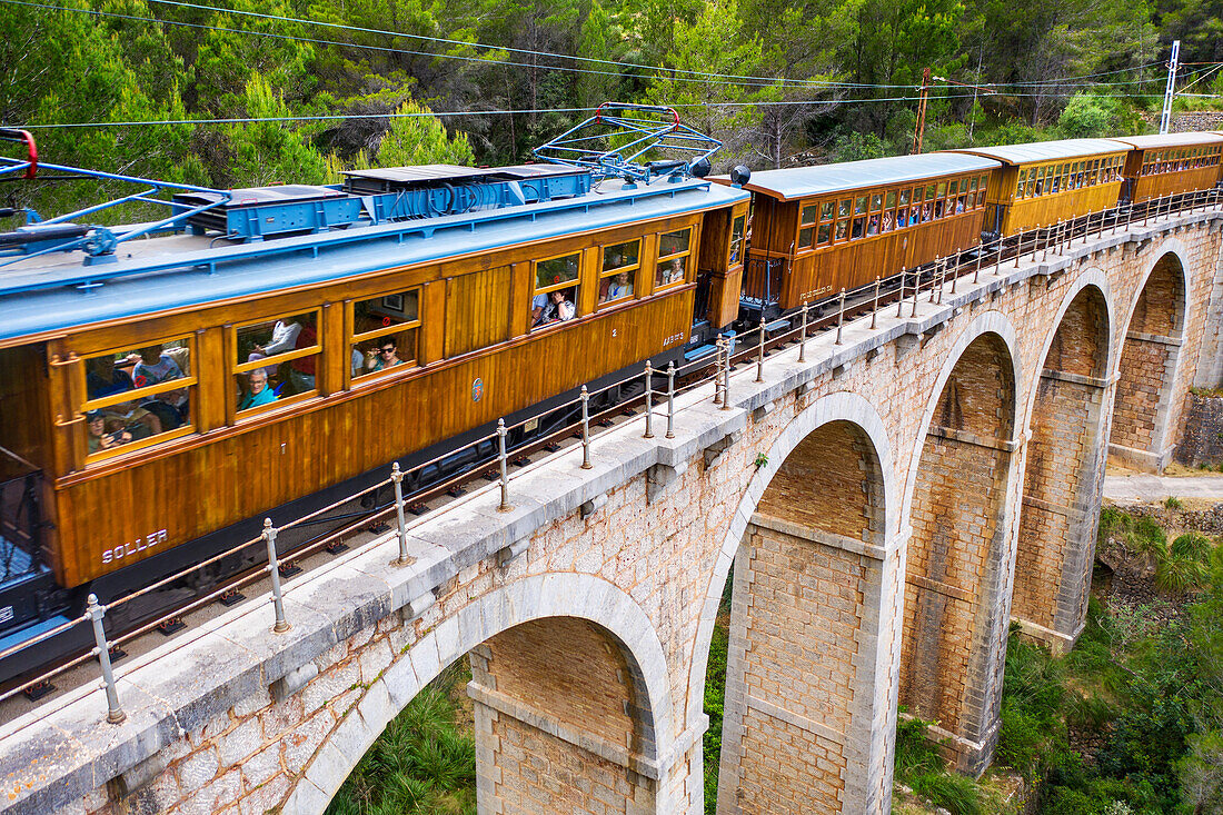 Luftaufnahme des Tren de Soller, eines historischen Zuges, der das Viadukt Cinc-Ponts überquert. Dieser Zug verbindet Palma de Mallorca mit Soller, Mallorca, Balearische Inseln, Spanien, Mittelmeer, Europa