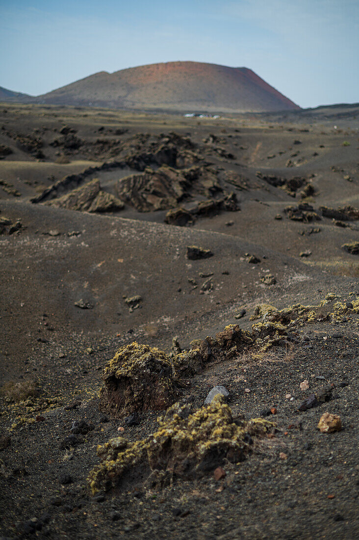 Volcan del Cuervo (Krähenvulkan) ein Krater, der auf einem Rundweg in einer kargen, felsigen Landschaft erkundet wird