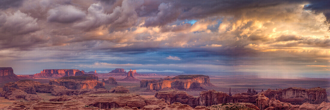 Colorful sunrise panorama of Monument Valley with a rain squall, from Hunt's Mesa. Monument Navajo Valley Tribal Park, Arizona.