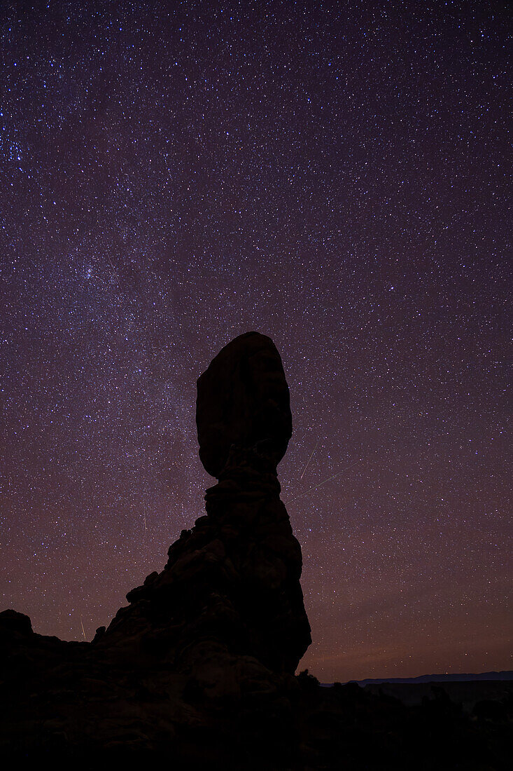 Geminid Meteor Shower over Balanced Rock in Arches National Park in Utah. Composite image shows 5 faint meteorites over a 2-hour period.