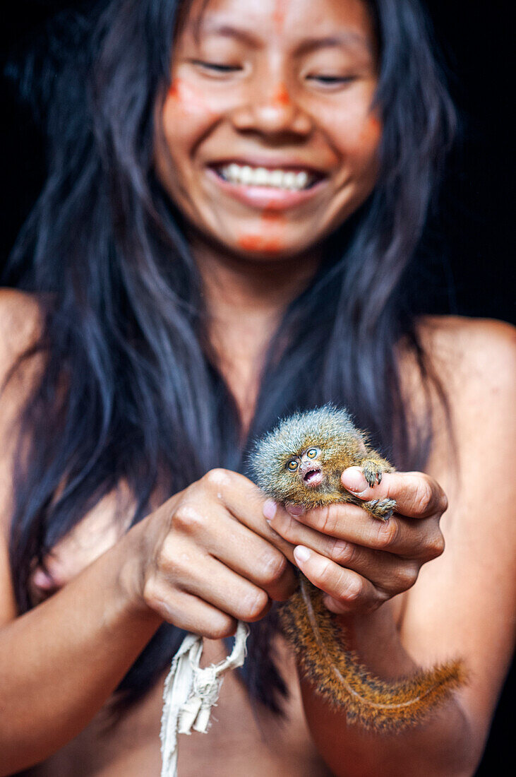 Pet pygmy marmoset Yagua Indians living a traditional life near the Amazonian city of Iquitos, Peru.