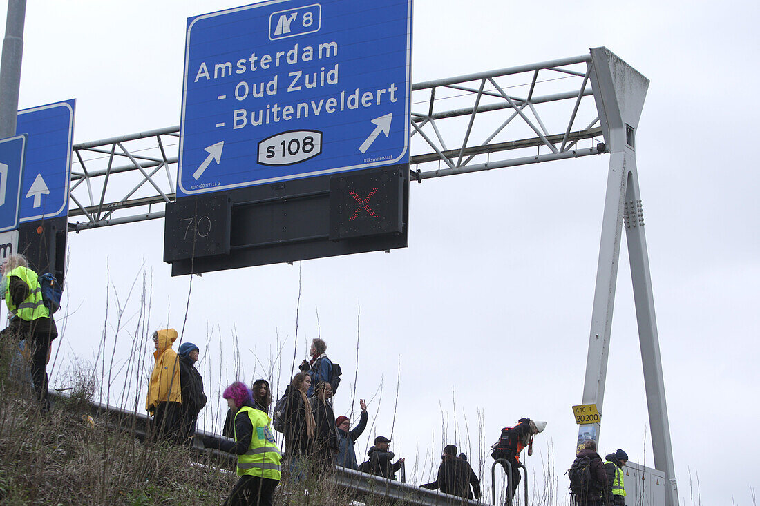 Extinction Rebellion climate activists gather to block the main highway A10 in front of the former headquarters of Dutch multinational bank on December 30, 2023 in Amsterdam,Netherlands. Environmental protectors of Extinction Rebellion make a demonstration against ING bank to protest its financing of fossil fuels.