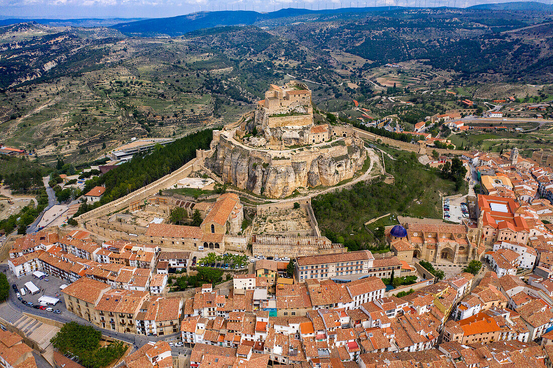 Aerial sunset view of Morella, medieval walled town with semi circular towers and gate houses crowed by a fortress on the rock in Spain, Valencia comunity, Castellon province.