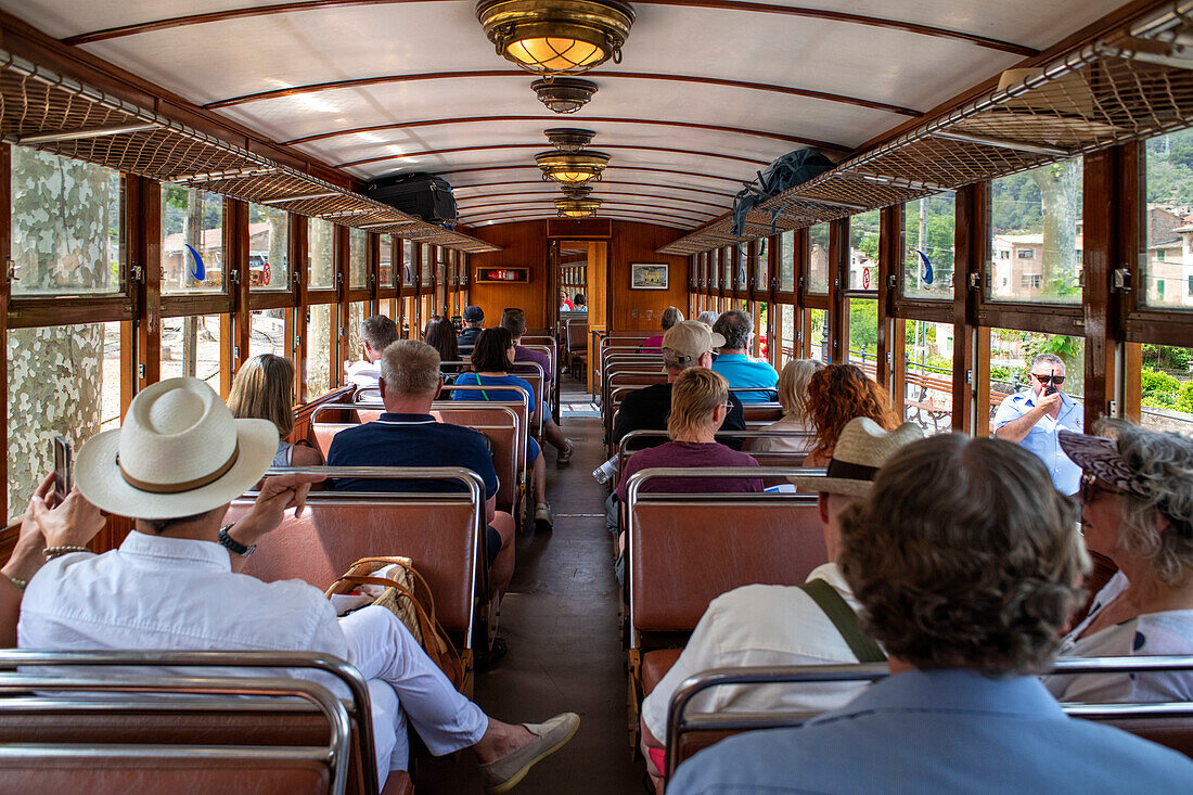 Touristen im Inneren des Tren de Soller, eines historischen Zuges, der Palma de Mallorca mit Soller verbindet, Mallorca, Balearen, Spanien, Mittelmeer, Europa