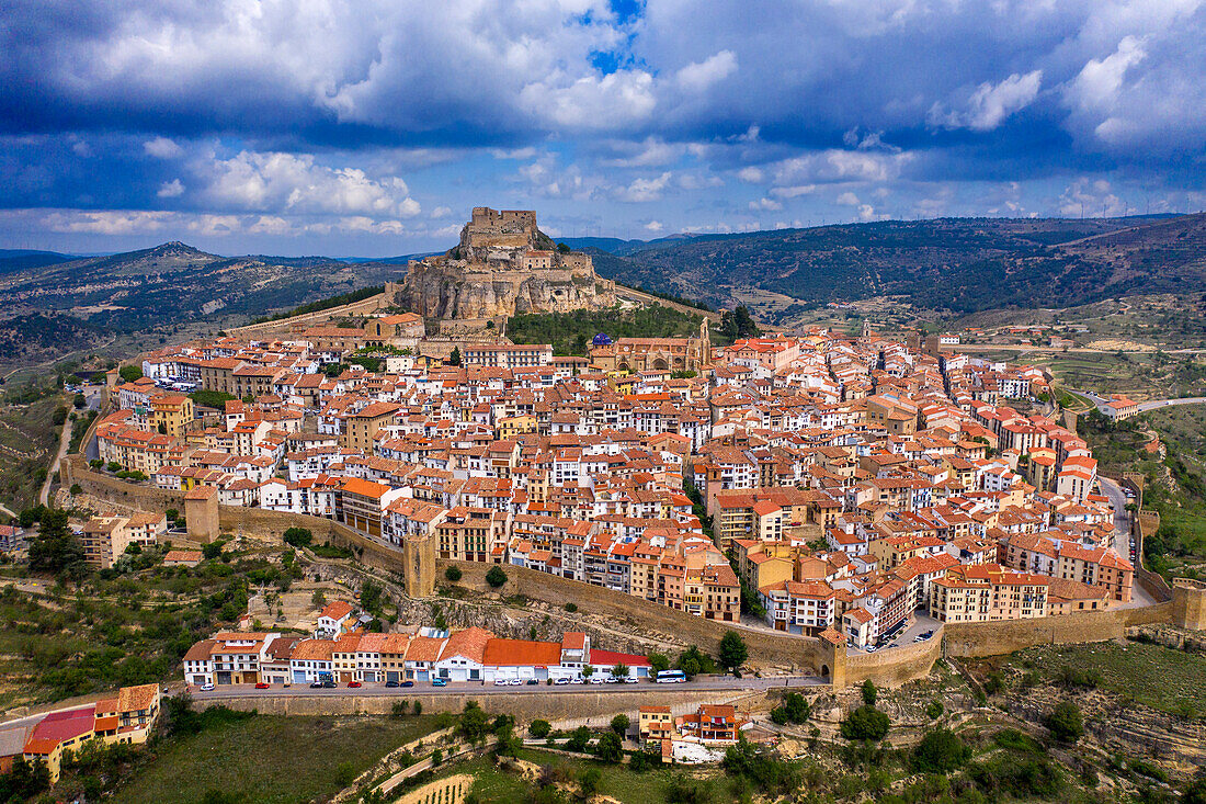 Aerial sunset view of Morella, medieval walled town with semi circular towers and gate houses crowed by a fortress on the rock in Spain, Valencia comunity, Castellon province.