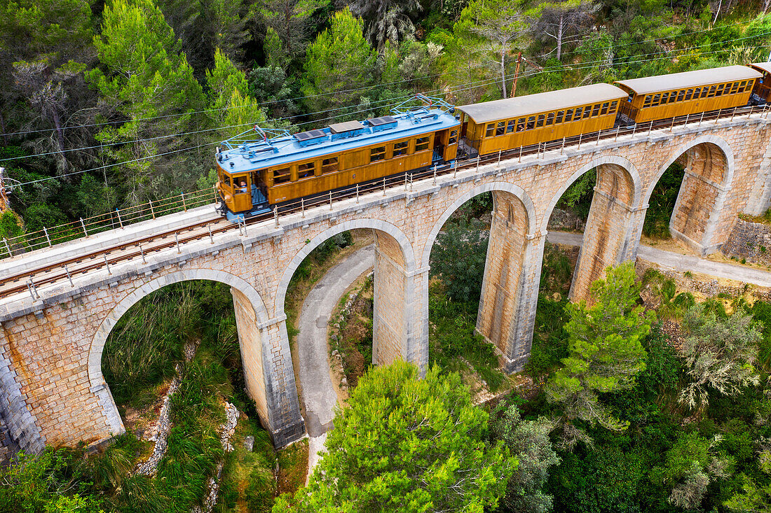 Luftaufnahme des Tren de Soller, eines historischen Zuges, der das Viadukt Cinc-Ponts überquert. Dieser Zug verbindet Palma de Mallorca mit Soller, Mallorca, Balearische Inseln, Spanien, Mittelmeer, Europa
