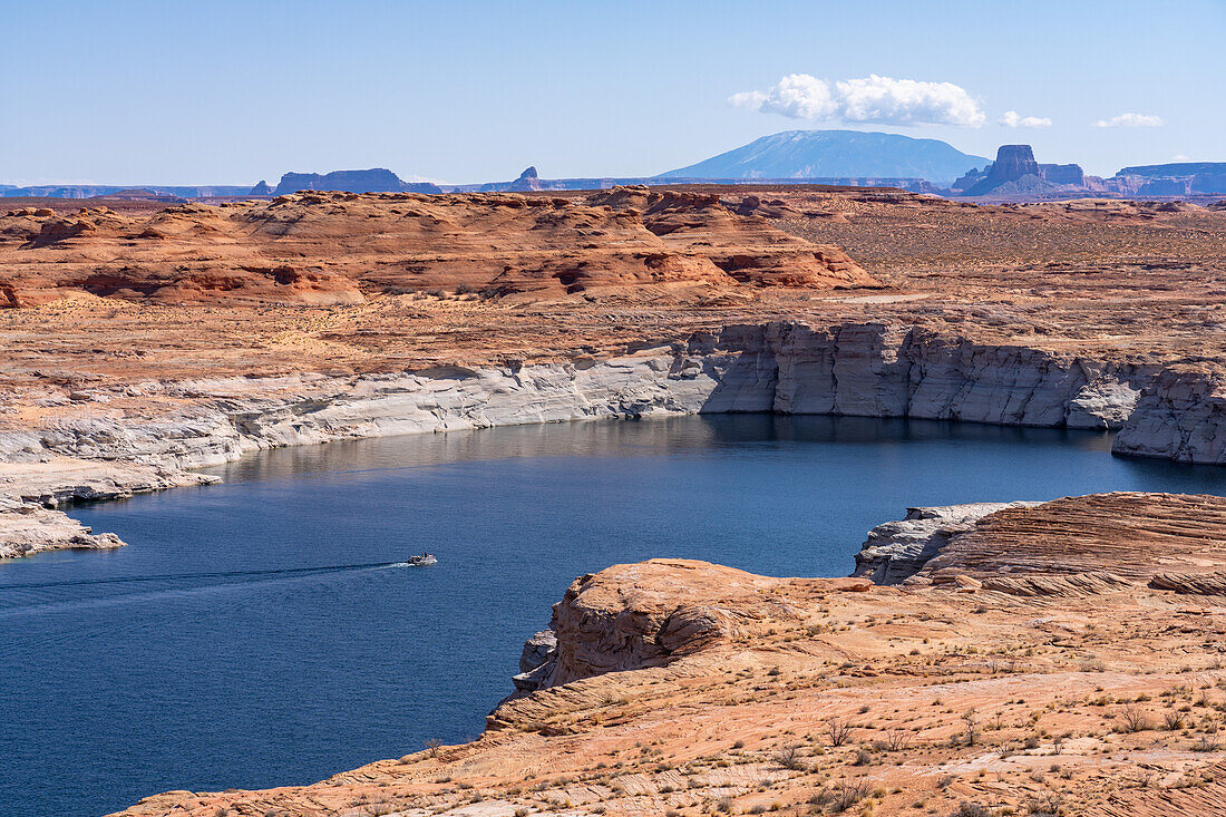 Boaters on Lake Powell in the Glen Canyon National Recreation Area, Arizona, with Navajo Mountain & Tower Butte behind.