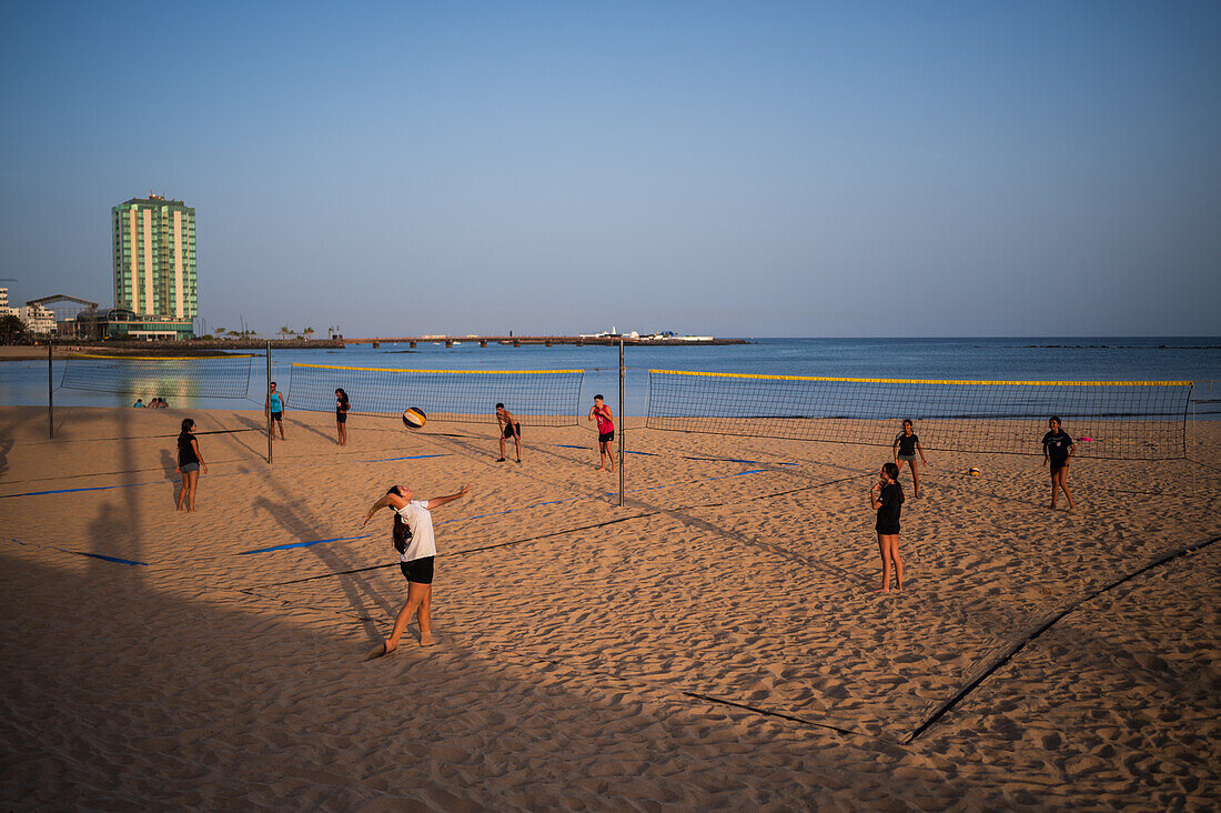 Kids playing volleyball on Arrecife beach in capital city of Lanzarote, Canary Islands, Spain