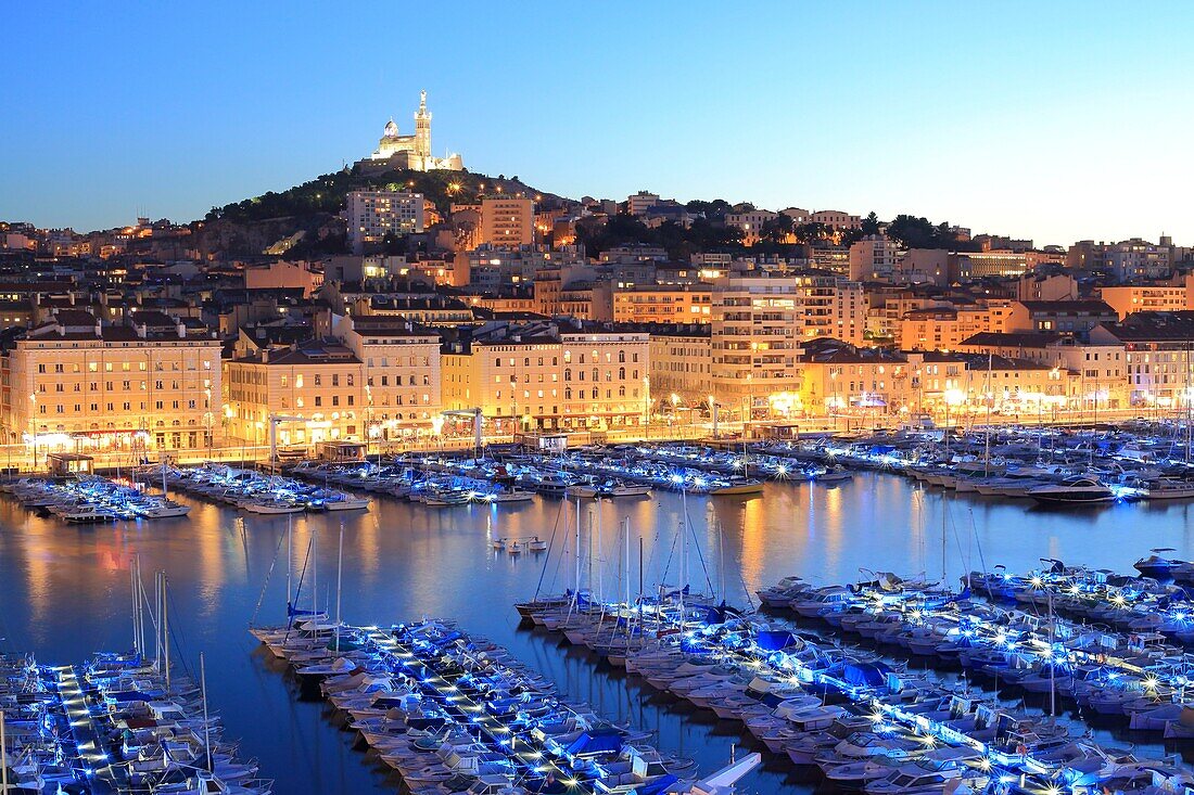 Frankreich, Bouches du Rhone, Marseille, Vieux Port bei Einbruch der Dunkelheit mit der Basilika Notre Dame de la Garde am Fuße