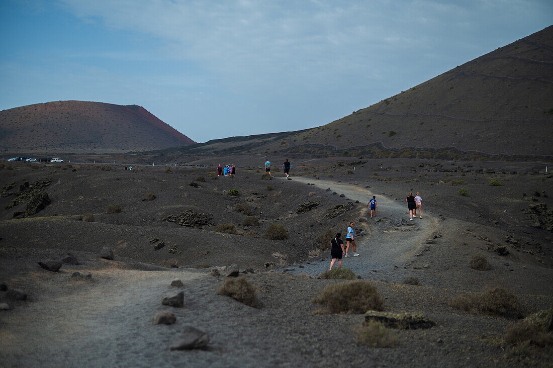 Volcan del Cuervo (Krähenvulkan) ein Krater, der durch einen Rundweg in einer kargen, felsigen Landschaft erkundet wird