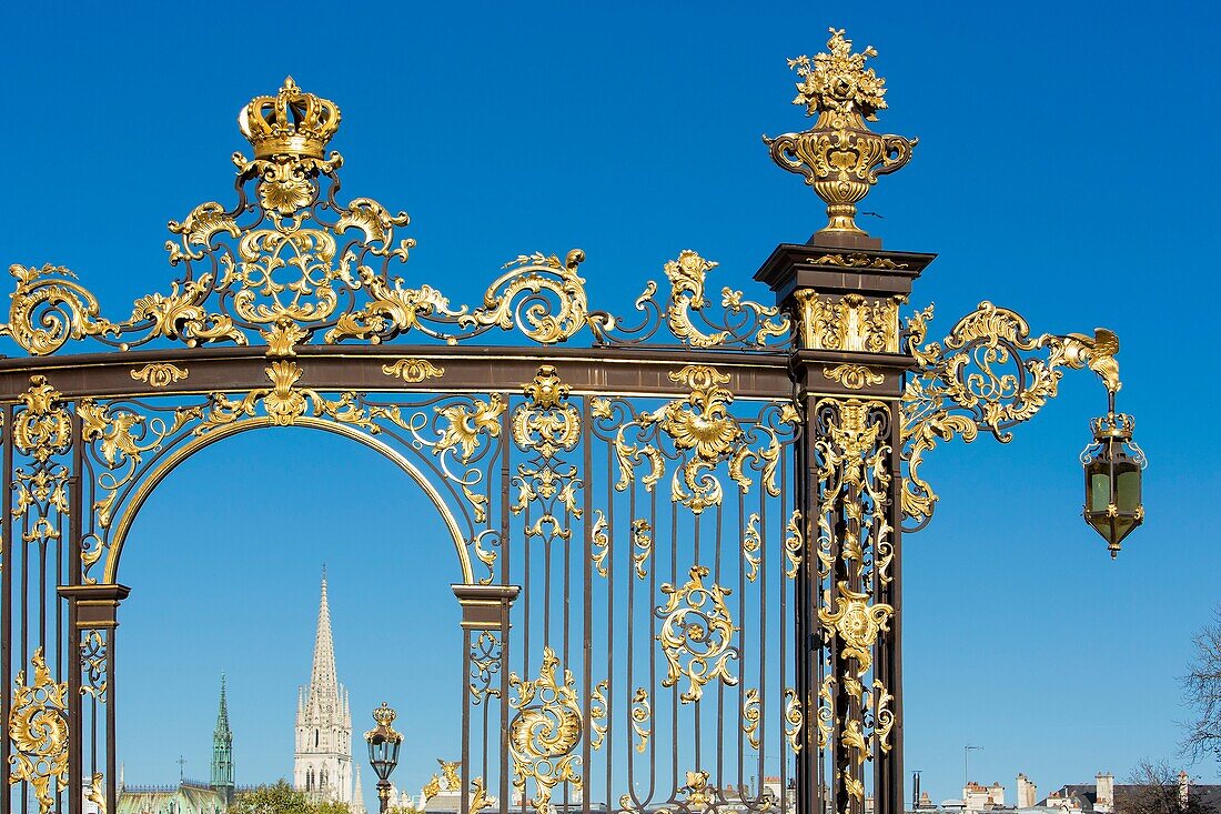 France, Meurthe et Moselle, Nancy, Stanislas square (former royal square) built by Stanislas Leszczynski, king of Poland and last duke of Lorraine in the 18th century, listed as World Heritage by UNESCO, railing and street lamp by Jean Lamour, bellfry of Saint Epvre basilica in the background