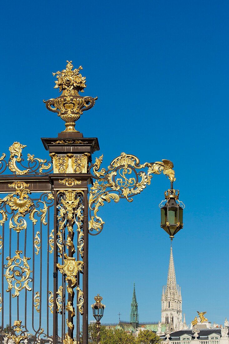 France, Meurthe et Moselle, Nancy, Stanislas square (former royal square) built by Stanislas Leszczynski, king of Poland and last duke of Lorraine in the 18th century, listed as World Heritage by UNESCO, railing and street lamp by Jean Lamour, bellfry of Saint Epvre basilica in the background