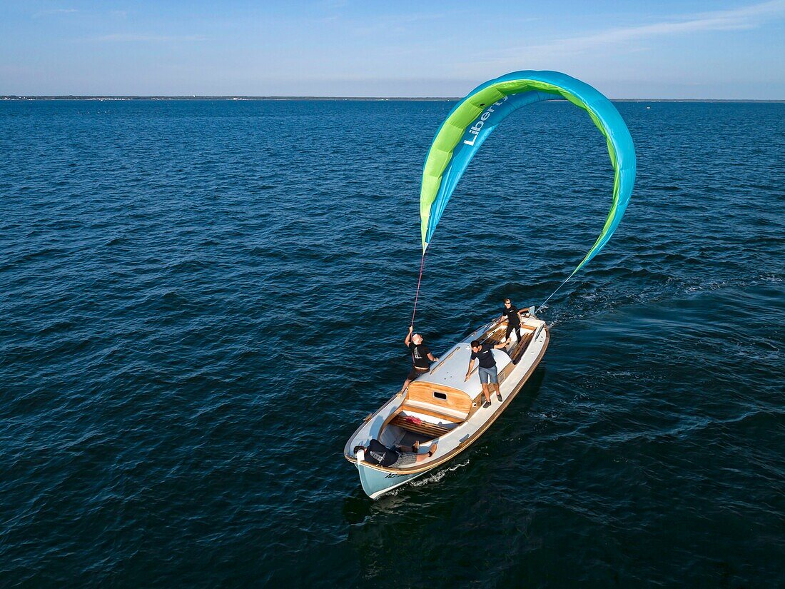 Frankreich, Gironde, Bassin d'Arcachon, Arcachon, Pinasse (traditionelles Boot), das von einem Drachensegel gezogen wird, der LibertyKite® ist ein Konzept, das von dem Seefahrtingenieur Yves Parlier und seiner Firma Beyond de Sea entwickelt wurde (Luftaufnahme)