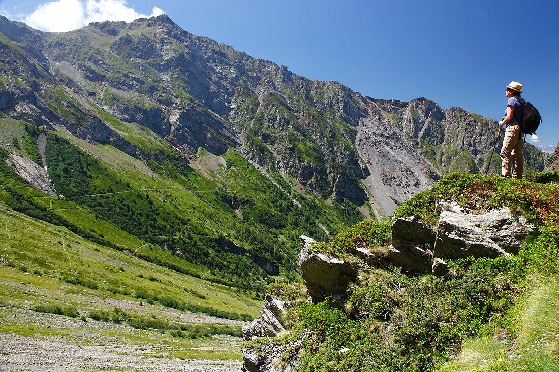 France, Isere, Lavaldens, Female hiker watching the Coiro summit, on the path toward Rif bruyant lake