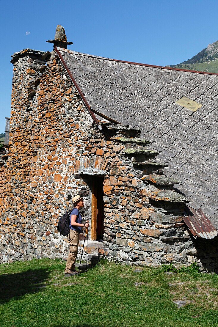 France, Isere, Lavaldens, Female hiker crossing the Rif Bruyant hamlet, on the path toward Rif bruyant lake