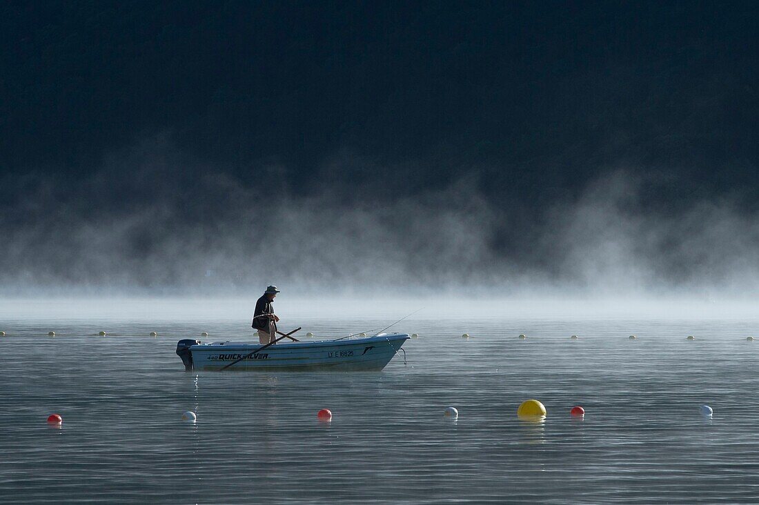 Frankreich, Haute Savoie, Annecy-See, Pecheur auf einem Boot im Morgen(früh)nebel vor dem Strand von Doussard