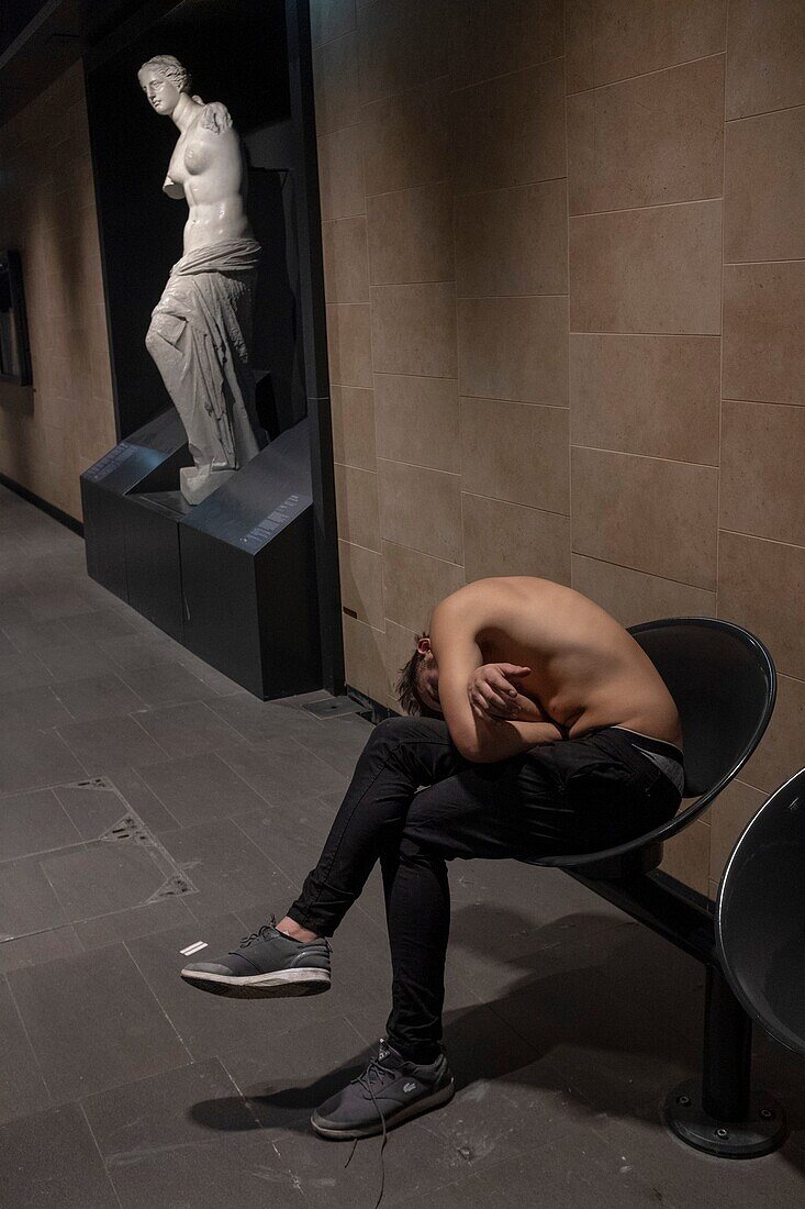 France, Paris, the Louvre-Rivoli metro station, young man shirtless and asleep