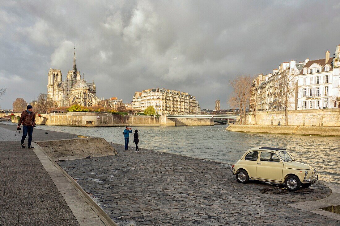 France, Paris, area listed as World Heritage by UNESCO, FIAT 500 in front of Saint Louis Island overlooking Notre Dame Cathedral
