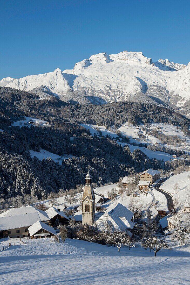 France, Haute Savoie, massif of Aravis, the village and the church of Manigod in front of massif of the mountain of Tournette after a snowfall