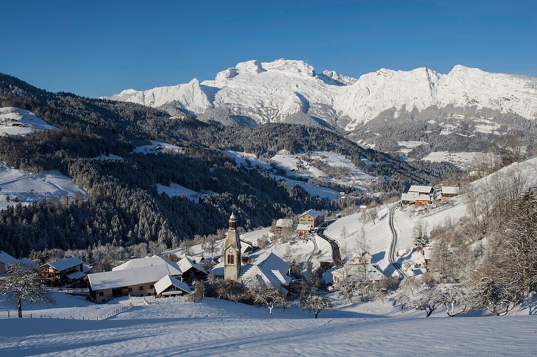 France, Haute Savoie, massif of Aravis, the village and the church of Manigod in front of massif of the mountain of Tournette after a snowfall