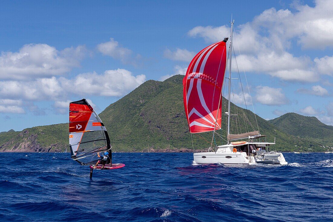 Martinique, Caribbean Sea, a catamaran under spinaker and a windsurfing board equipped with a foil