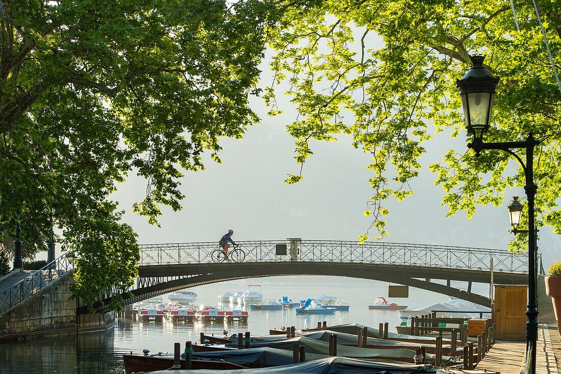 Frankreich, Haute Savoie, Annecy, Radfahrer auf der Brücke der Loves bei Sonnenaufgang und dem Beginn des Canal du Vasse