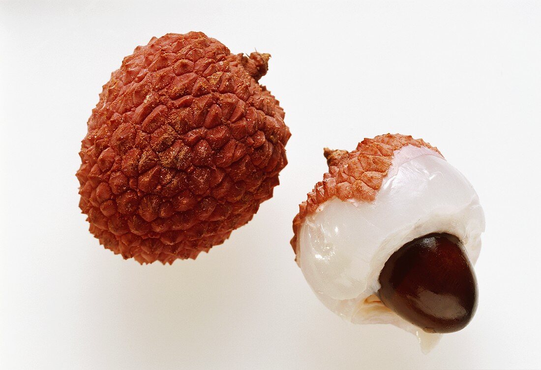 A whole lychee & half a peeled lychee with stone