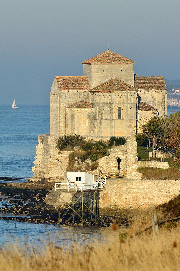 Frankreich, Charente Maritime, Saintonge, Mündung der Gironde, Saintonge, Talmont sur Gironde, ausgezeichnet als Les Plus Beaux Villages de France (Die schönsten Dörfer Frankreichs), Hütten auf Stelzen für Carrelet (Fischerhütte) Fischernetz und Sainte Radegonde Kirche in Saintonge romanischer Stil aus dem 12.