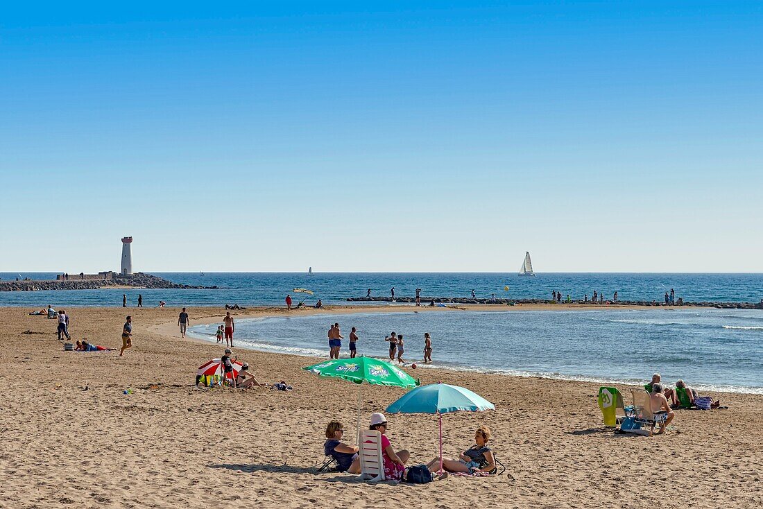 Frankreich, Herault, Agde, Urlauber an einem Strand im Schatten eines Sonnenschirms