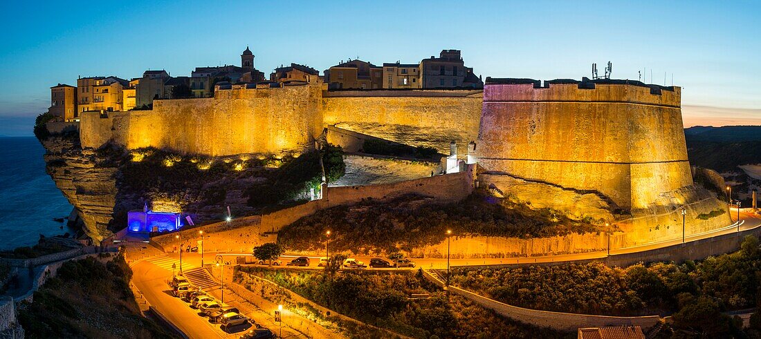 Frankreich, Corse du Sud, Bonifacio, Panorama des Lichtspiels auf der Zitadelle und der Bastion des Etendard vom Fußweg der Klippen aus gesehen in der Abenddämmerung