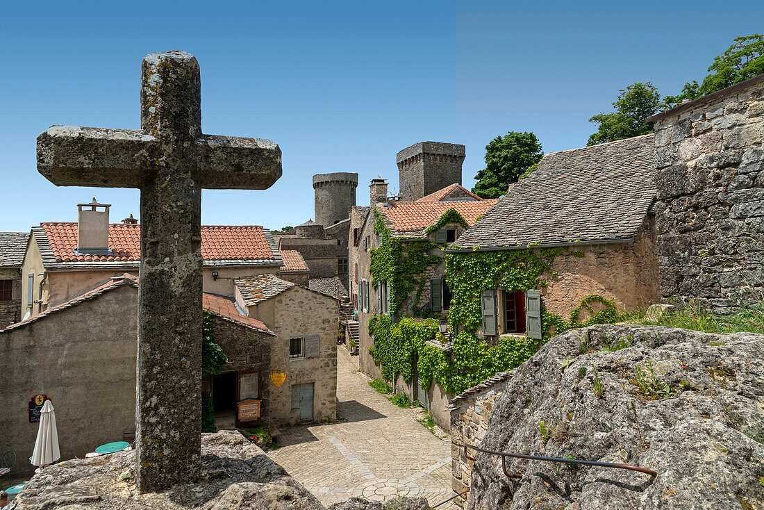 Frankreich, Aveyron, La Couvertoirade, beschriftet mit Les Plus Beaux Villages de France (Die schönsten Dörfer Frankreichs), dominanter Blick auf einen Dorfkern mit Steinkreuz im Vordergrund
