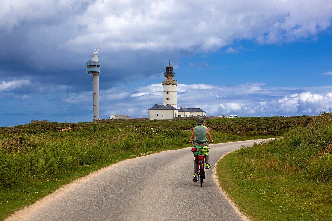 France, Finistere, Ponant Islands, Armorica Regional Nature Park, Iroise Sea, Ouessant Island, Biosphere Reserve (UNESCO), Cyclist riding towards the Stiff Lighthouse listed as a Historic Monument