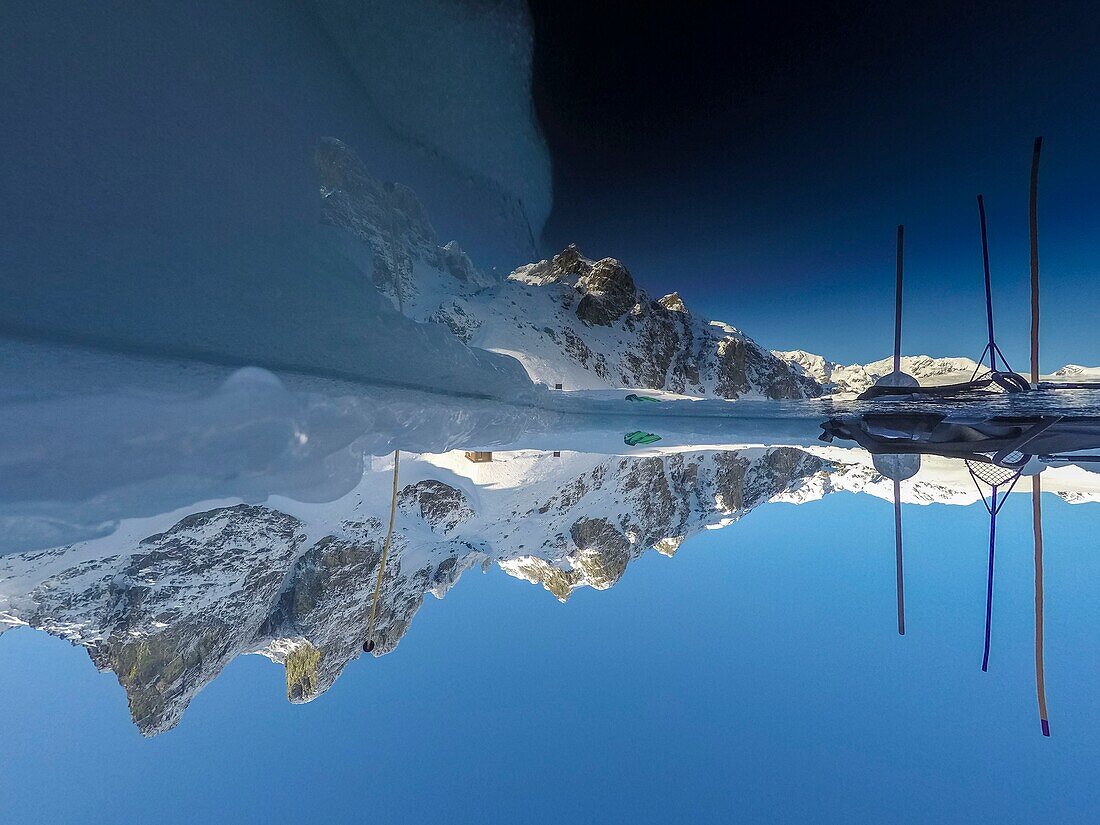 Frankreich, Isère (38), Belledonne, Chamrousse, die Seen von Robert, die im Osten von Petit Van (2 439 m), Grand Van (2 448 m) und Grand Sorbier (2 526 m) begrenzt und dominiert werden, spiegeln die Berggipfel durch ein ins Eis gegrabenes Loch, das das Tauchen ermöglicht