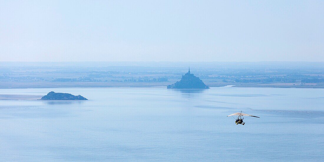 France, Manche, Le Mont Saint Michel, listed as World Heritage by UNESCO, weightshift ultralight flying toward Tombelaine and Mont Saint Michel (aerial view)