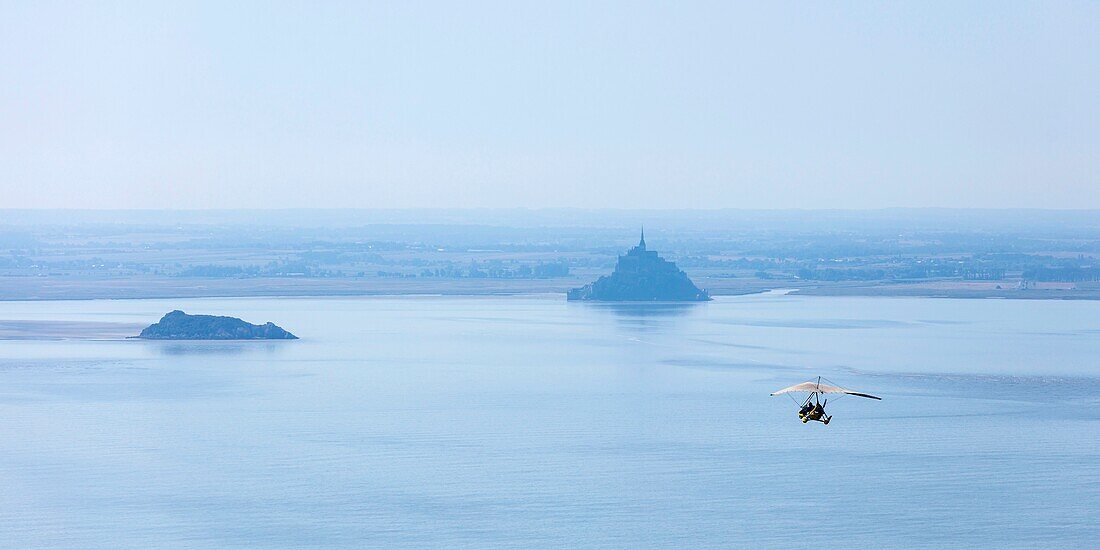 Frankreich, Manche, Le Mont Saint Michel, von der UNESCO zum Weltkulturerbe erklärt, Ultraleichtflugzeug mit Gewicht in Richtung Tombelaine und Mont Saint Michel (Luftaufnahme)