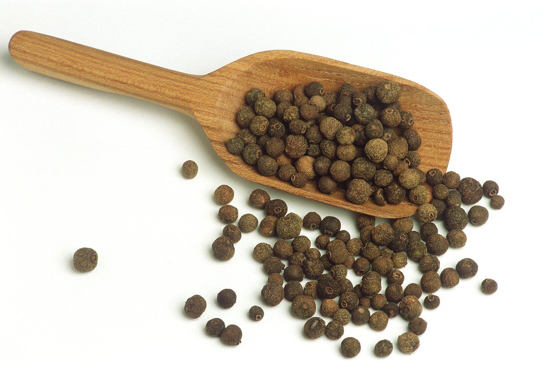 Pimento berries on wooden scoop