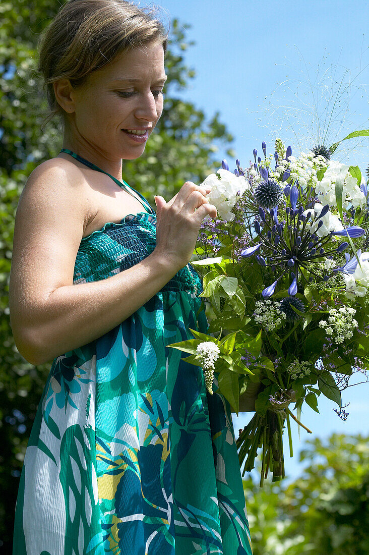 Frau hält Blumenstrauß mit Sommerblumen