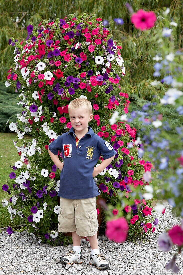 Boy in front of large petunia container