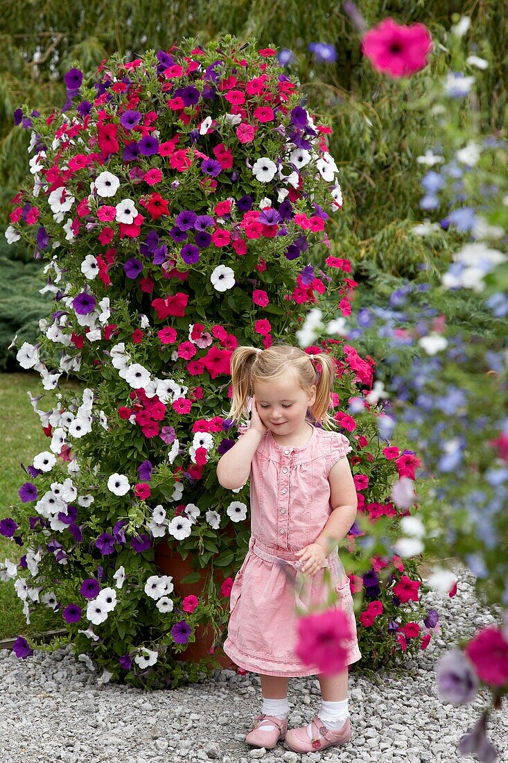 Girl in front of large petunia container